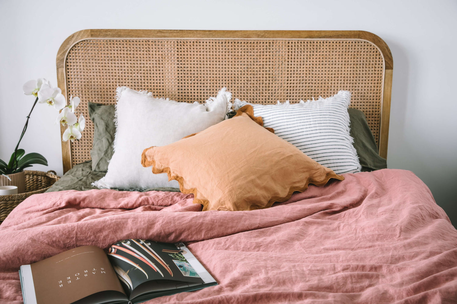 Beautifully styled bed with 100% European flax linen sheets and duvet cover in olive green and dusty pink. Styled with flax linen cushions with fringe and wave detailing