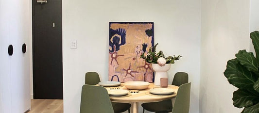 Tastefully styled dining breakfast table with artwork and fiddle leaf plant
